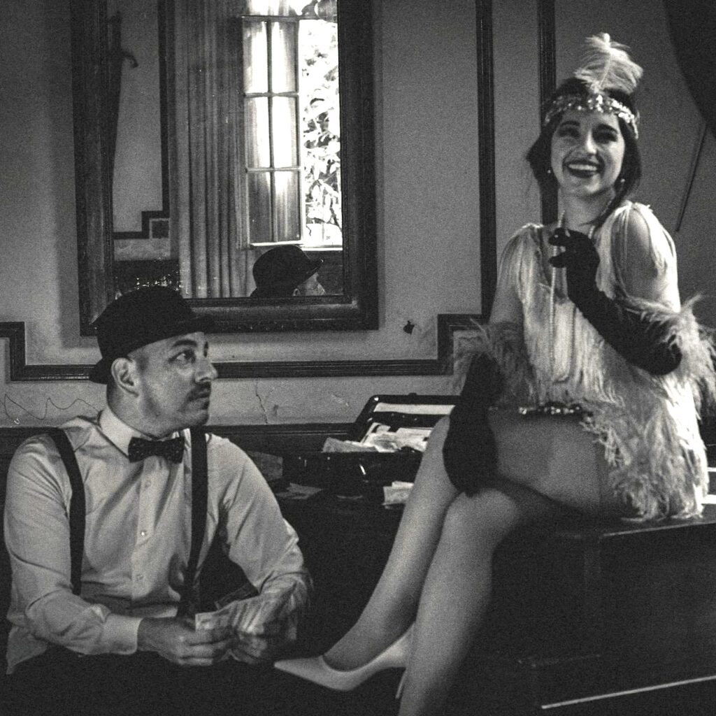 flapper woman on piano with man holding money